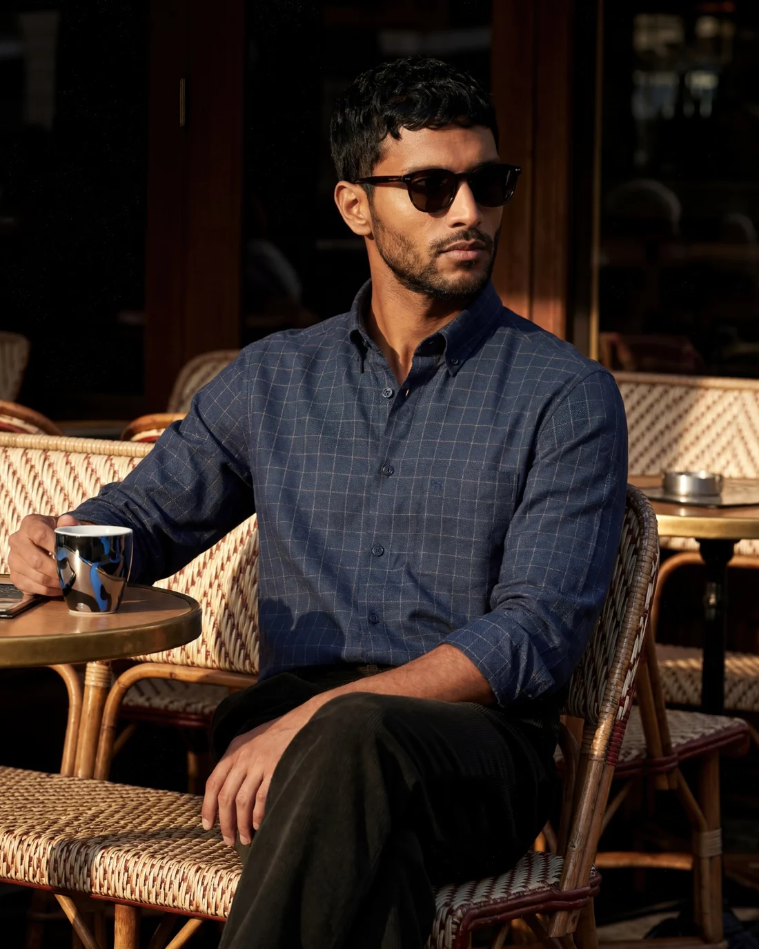 The same shirt worn on model at a cafe in late afternoon light.