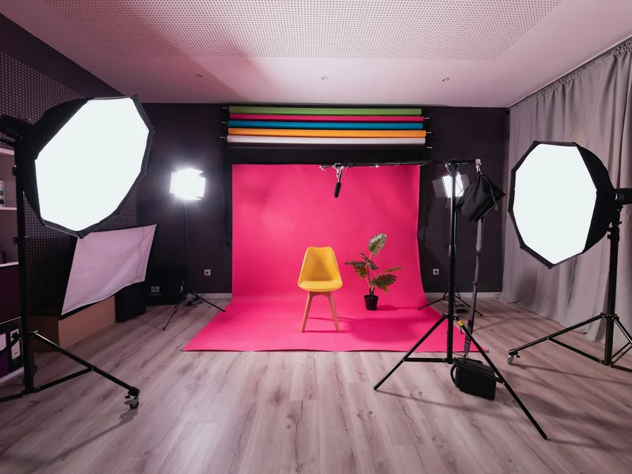 A photo studio with a pink backdrop and a yellow chair