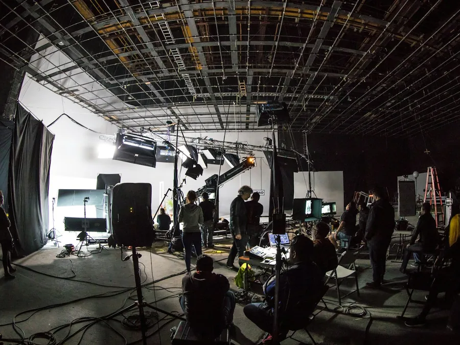 A film crew working on a soundstage with lights and cameras